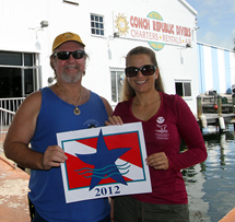 Florida Keys National Marine Sanctuary staff member LTjg Carmen Alex presents Conch Republic Divers owner Gary Mace with his charter's Blue Star decal and recognition.
