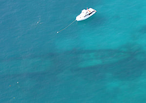 aerial view of A boat ties up to a mooring buoy
