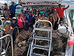 people posing with collected marine debris on a boat