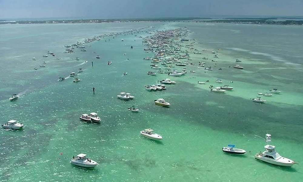 a large number of boats parked at a sand bar