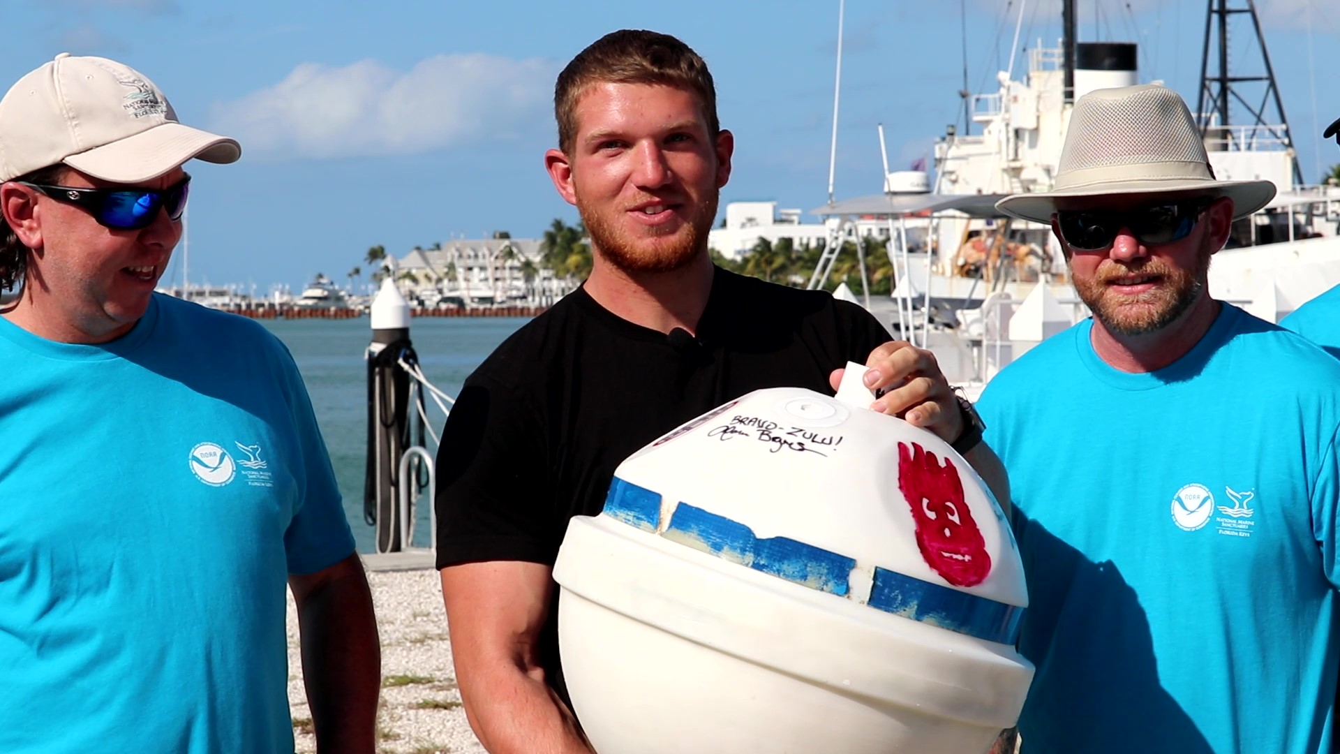 People pose with a buoy