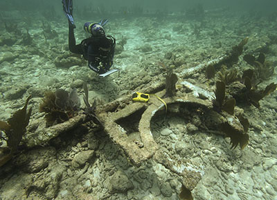 Photo of a researcher recording French Reef beacon pile and remains of letter 'G'. Photo credit: M. Lawrence.