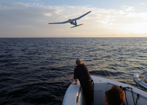 Photo of an unmanned aerial system flying over water.