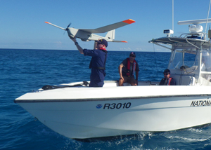 Photo of technician launching unmanned aerial system.